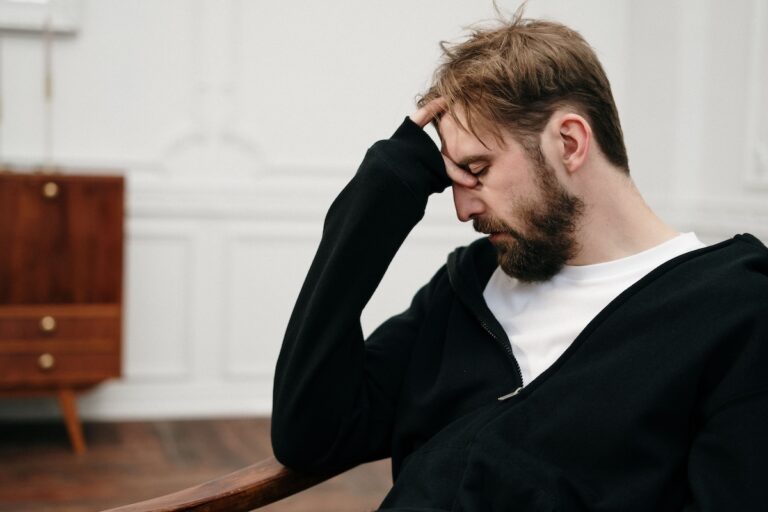 Man sitting in a chair with his head resting in his hand