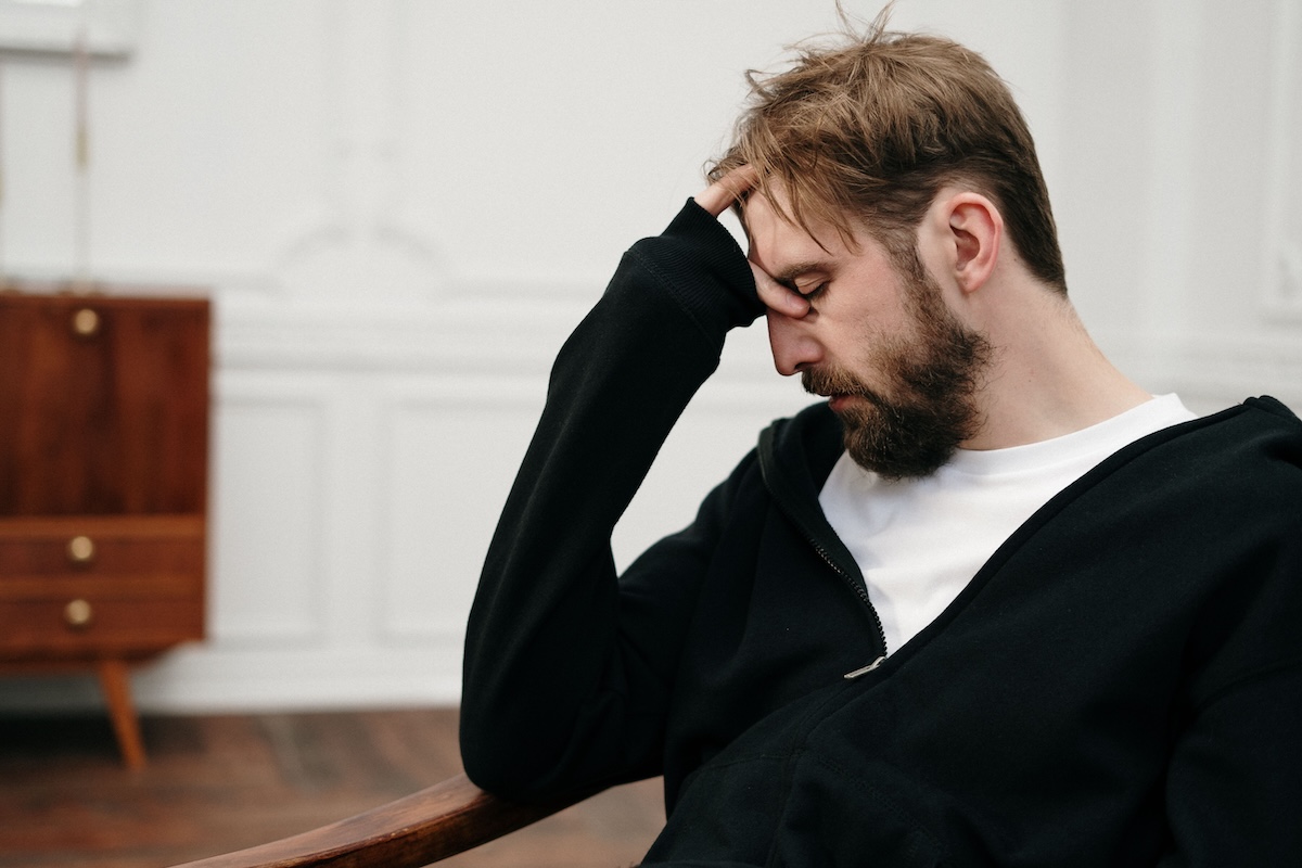 Man sitting in a chair with his head resting in his hand