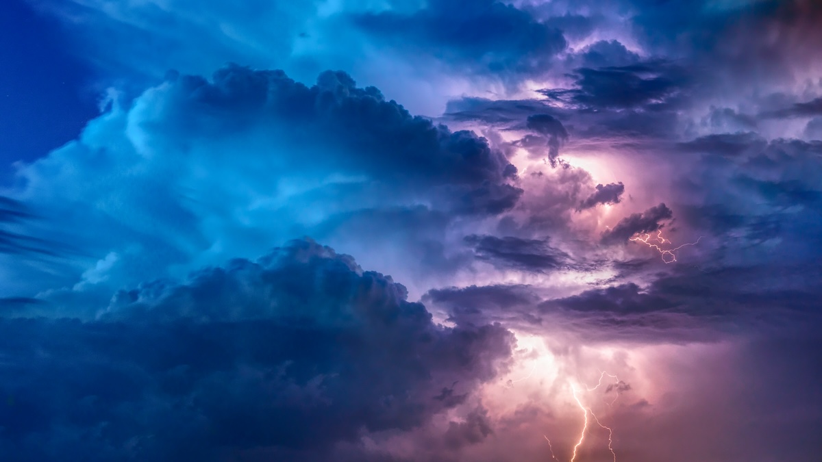 Dark storm clouds with lightning surrounding a bright center