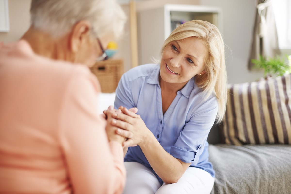 The Gifts Hidden in Caregiving Middle-aged caregiver holding the hands of an elderly woman
