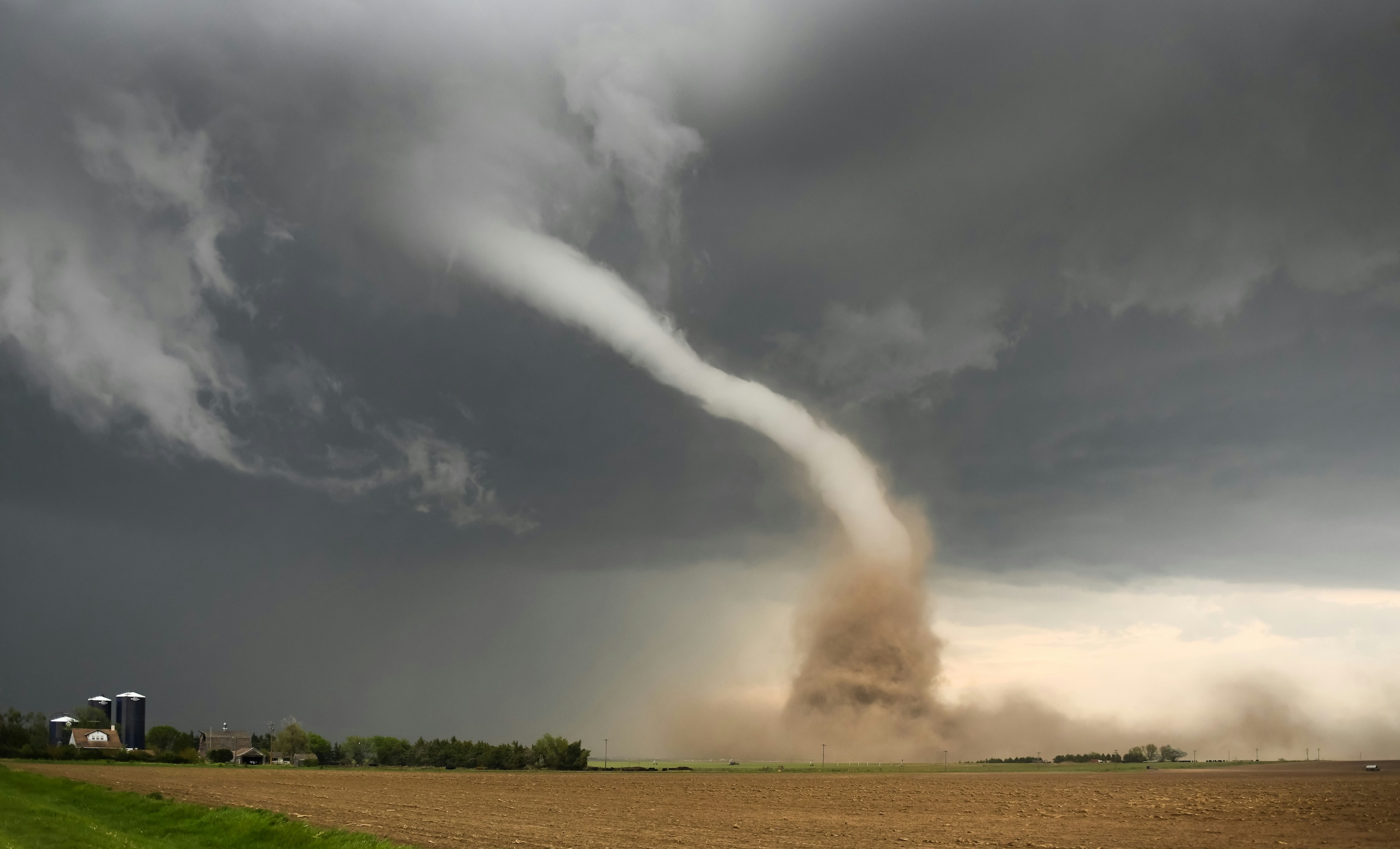 Dust storm swirling beneath a dark, stormy sky
