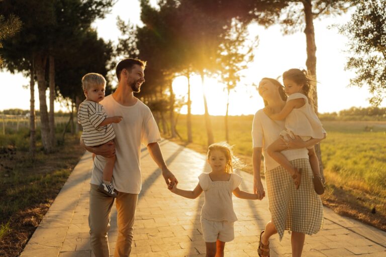 Family walking together along a tree-lined road