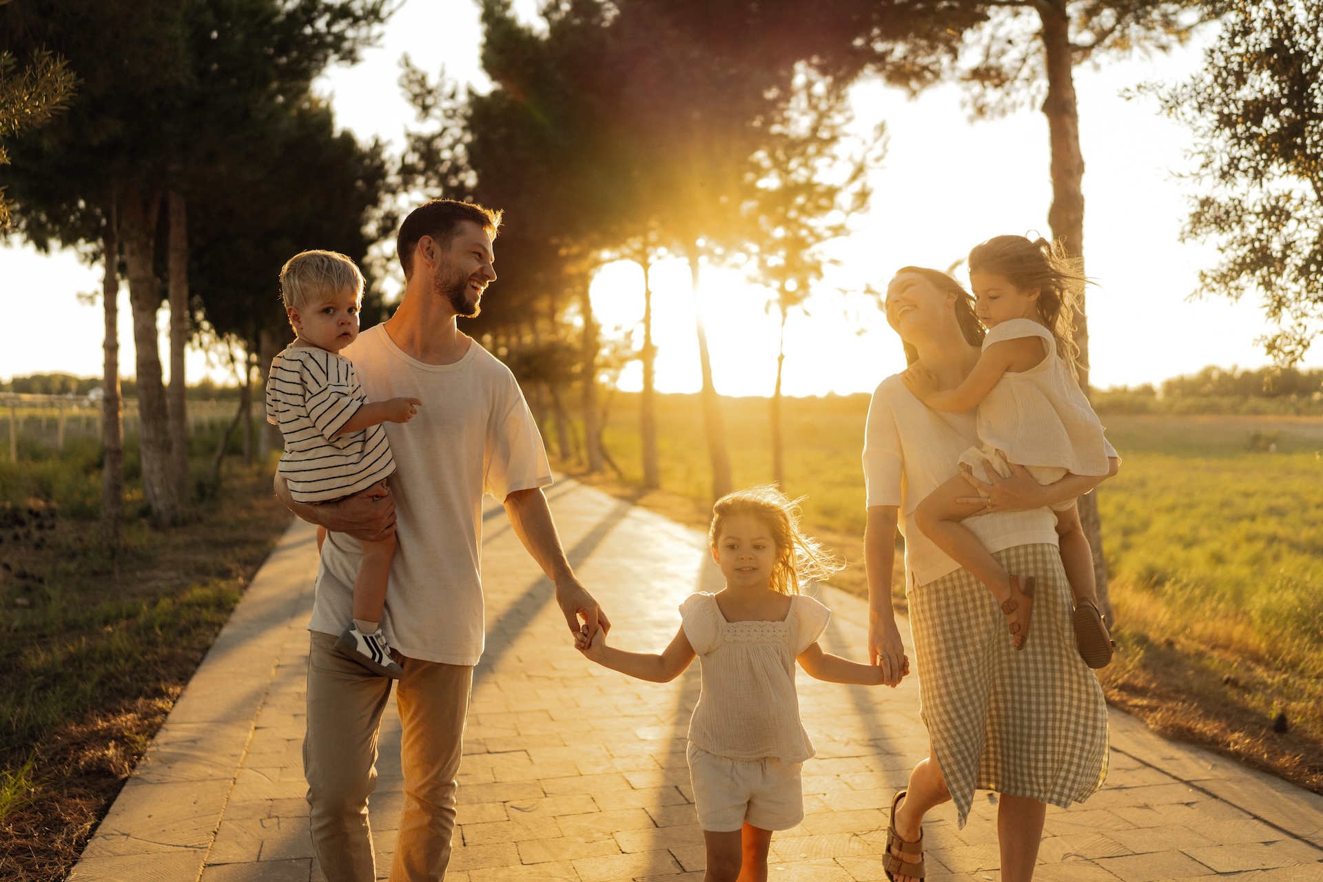 Family walking together along a tree-lined road