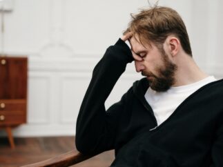 Man sitting in a chair with his head resting in his hand