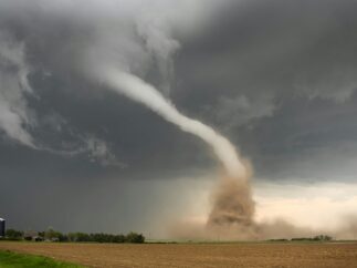 Dust storm swirling beneath a dark, stormy sky